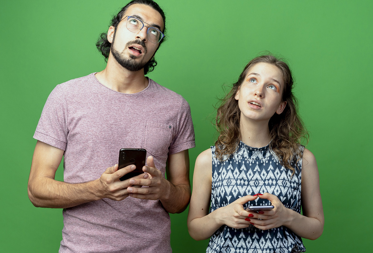Signs of social media overuse — man and woman distracted by phones instead of each other